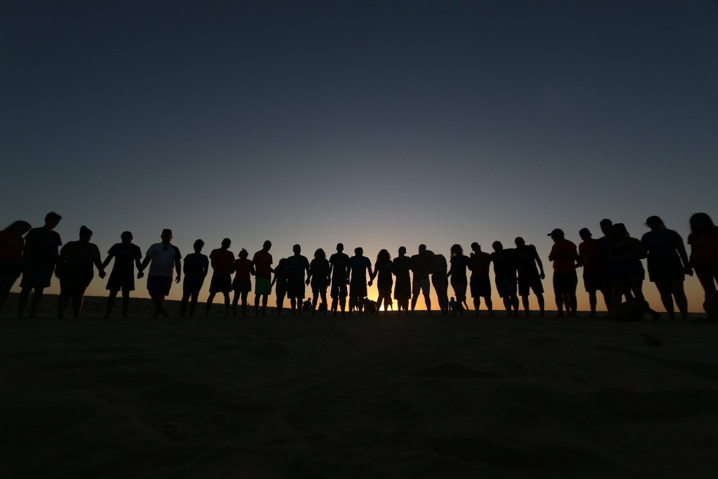 line of people sunset on hill