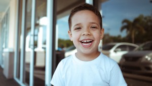 young boy in white shirt smiling